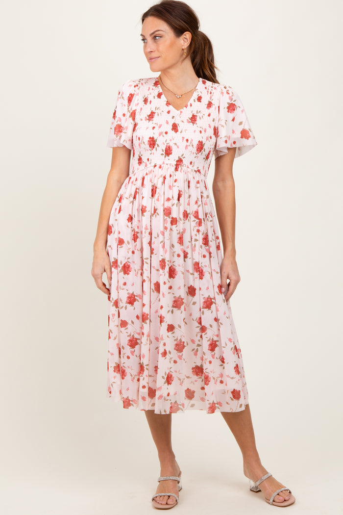 woman wearing a floral midi dress with short sleeves and a smocked bodice