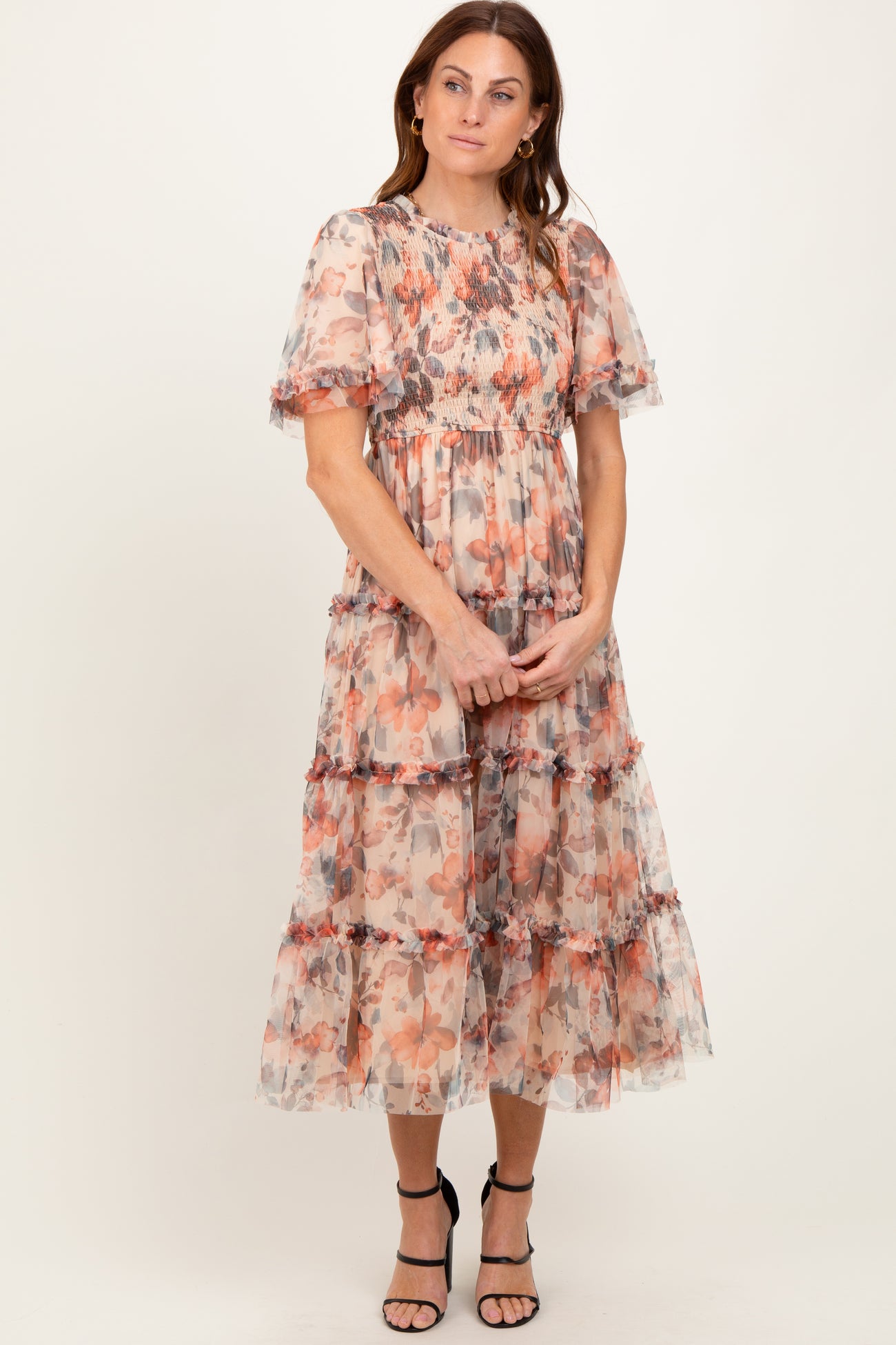 woman wearing a floral printed midi dress with ruffled tiers and short puff sleeves