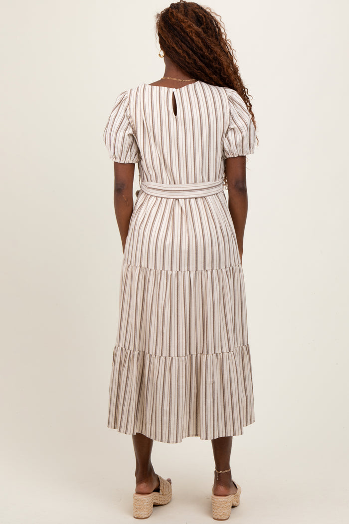 woman wearing a striped midi dress with puff sleeves and a belted waist, shown from the back
