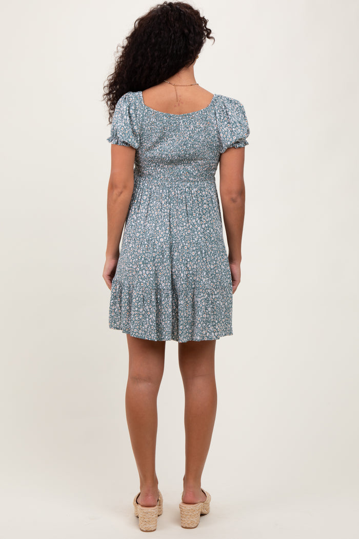 woman wearing a green floral print short sleeve dress with a fitted bodice and flared skirt from the back