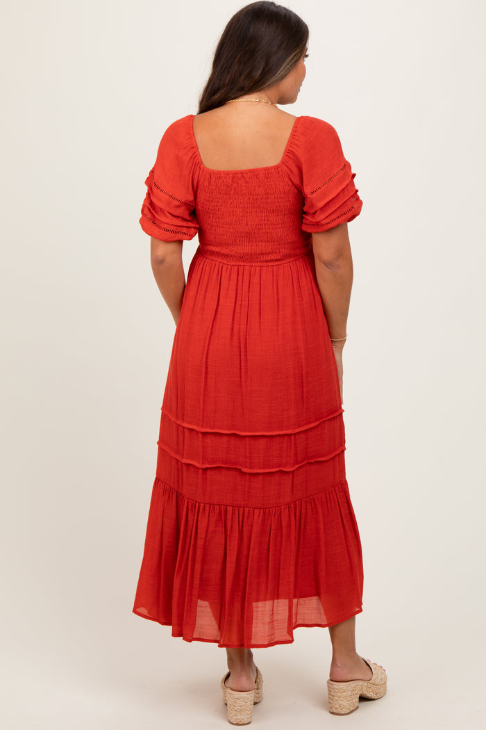 woman wearing a red maternity maxi dress with short puff sleeves and tiered skirt, shown from the back