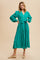woman wearing a teal long sleeve button-up dress with a cinched waist and flowing skirt