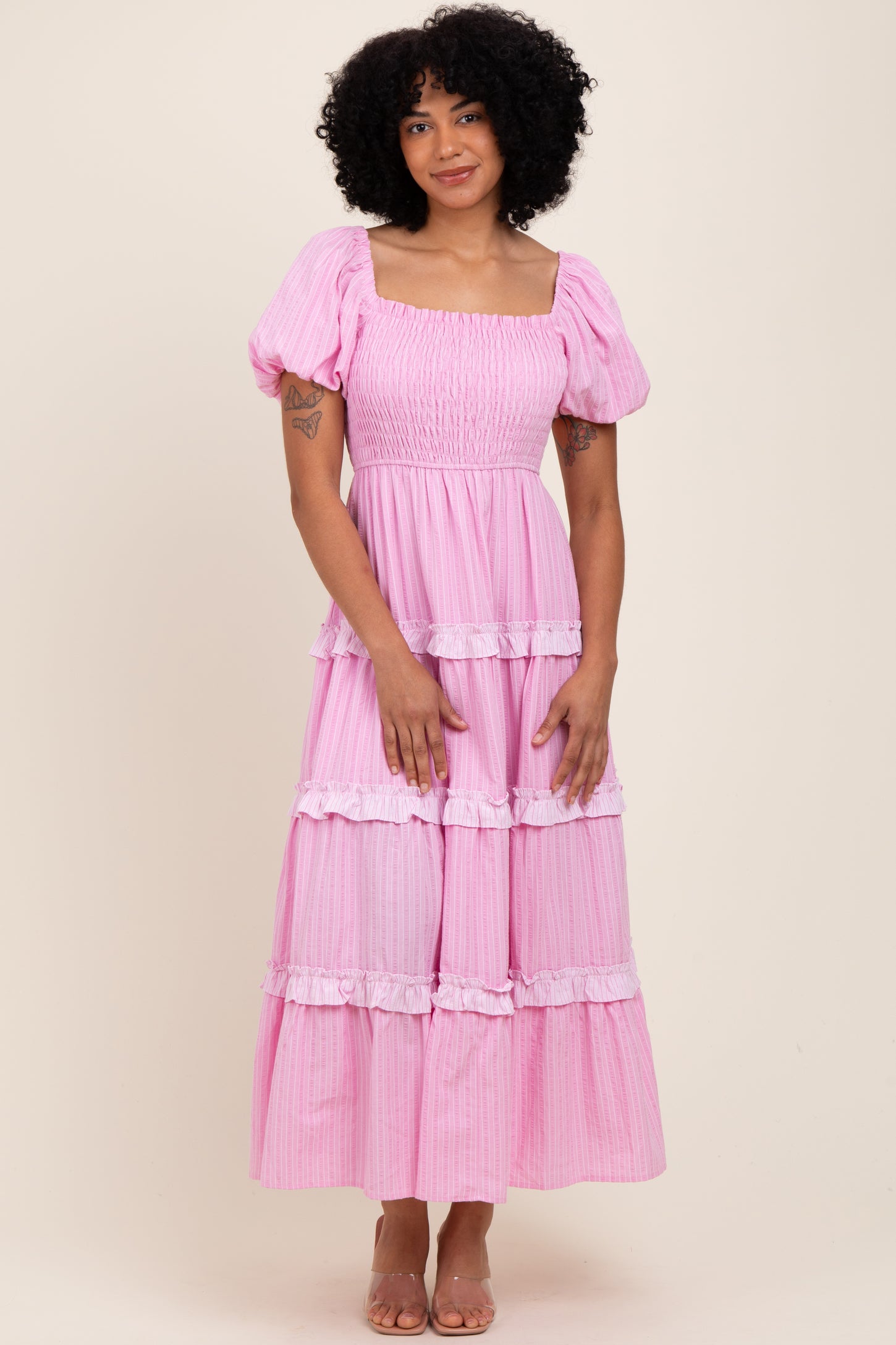 woman wearing a pink tiered maxi dress with puff sleeves and ruffle details