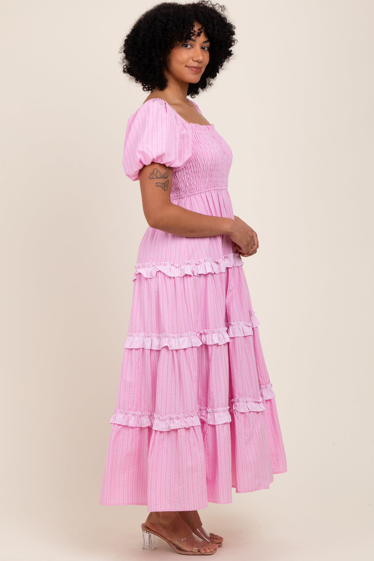 woman wearing a pink tiered maxi dress with puff sleeves and smocked bodice
