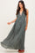 woman wearing a flowy olive green maxi dress with a deep v-neck and button details, standing gracefully