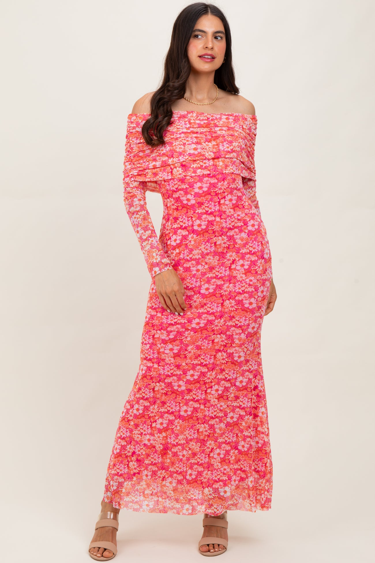 woman wearing a pink floral off-shoulder maxi dress with long sleeves and a fitted silhouette