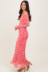 woman wearing a pink floral off-the-shoulder maxi dress with long sleeves and a flared hem