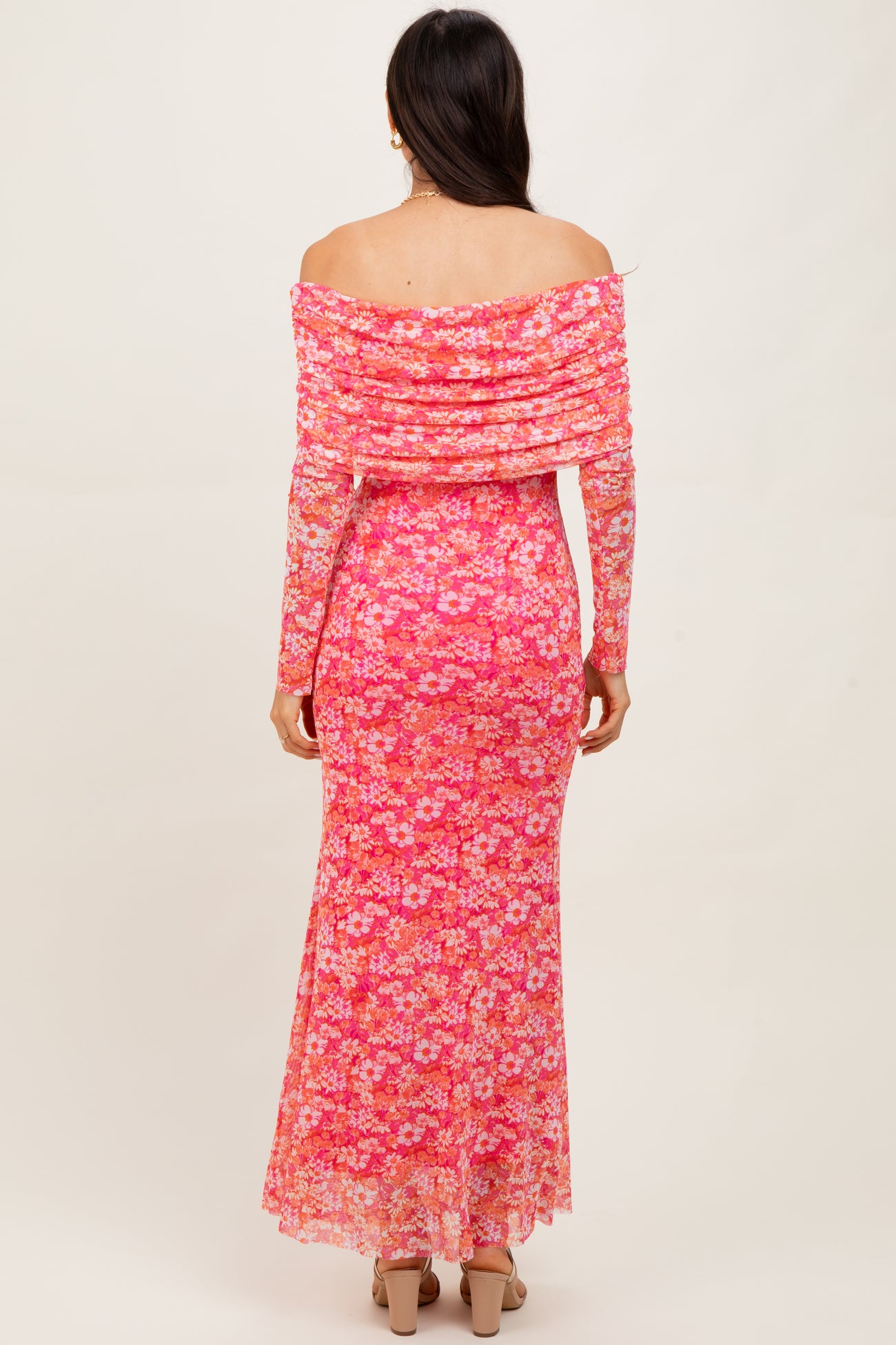 woman wearing a pink off-the-shoulder floral maxi dress with a fitted silhouette and sheer overlay