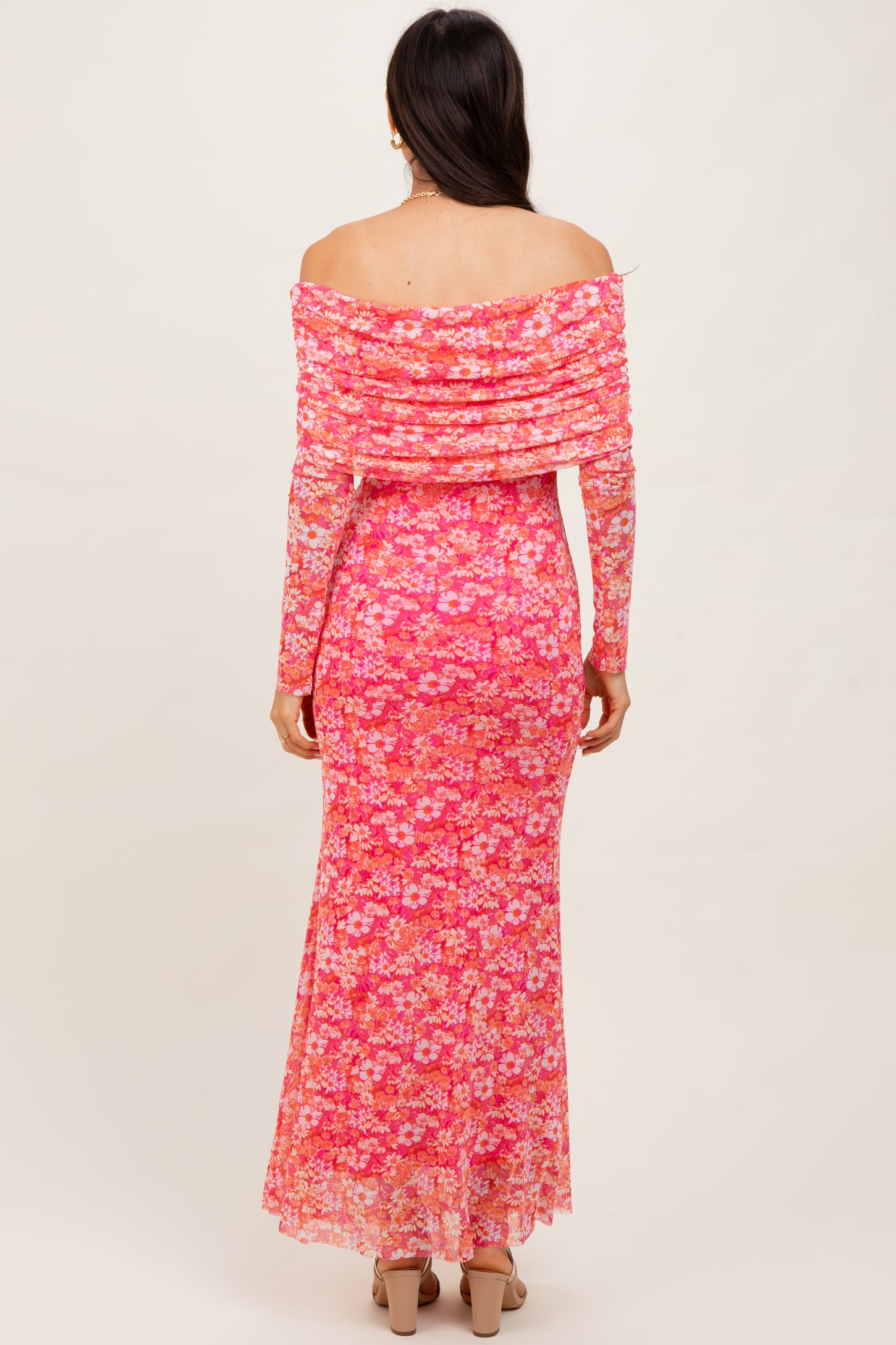 woman wearing a pink off-the-shoulder floral maxi dress with a fitted silhouette and sheer overlay