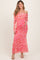 woman wearing a pink off-shoulder floral maternity dress and holding her baby bump
