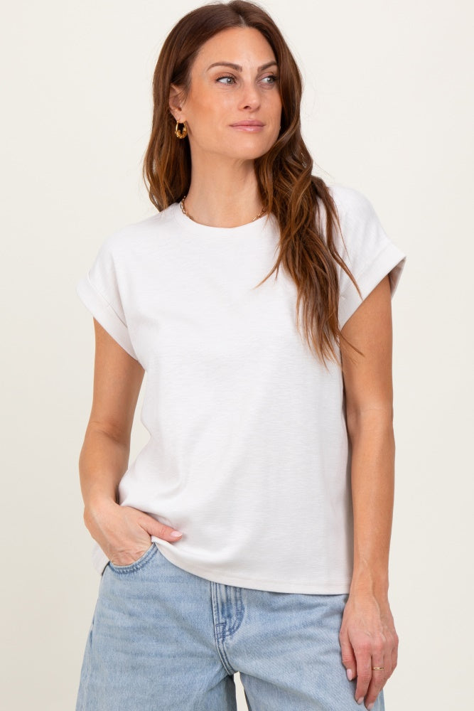 woman wearing a white short sleeve t-shirt with rolled cuffs and light blue high-waisted jeans