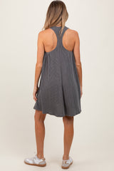 woman wearing a gray striped sleeveless maternity dress with a back cutout, relaxed fit, and white sneakers