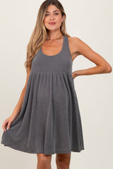 woman wearing a gray striped maternity dress with a flowy skirt and a fitted bodice, showcasing her baby bump