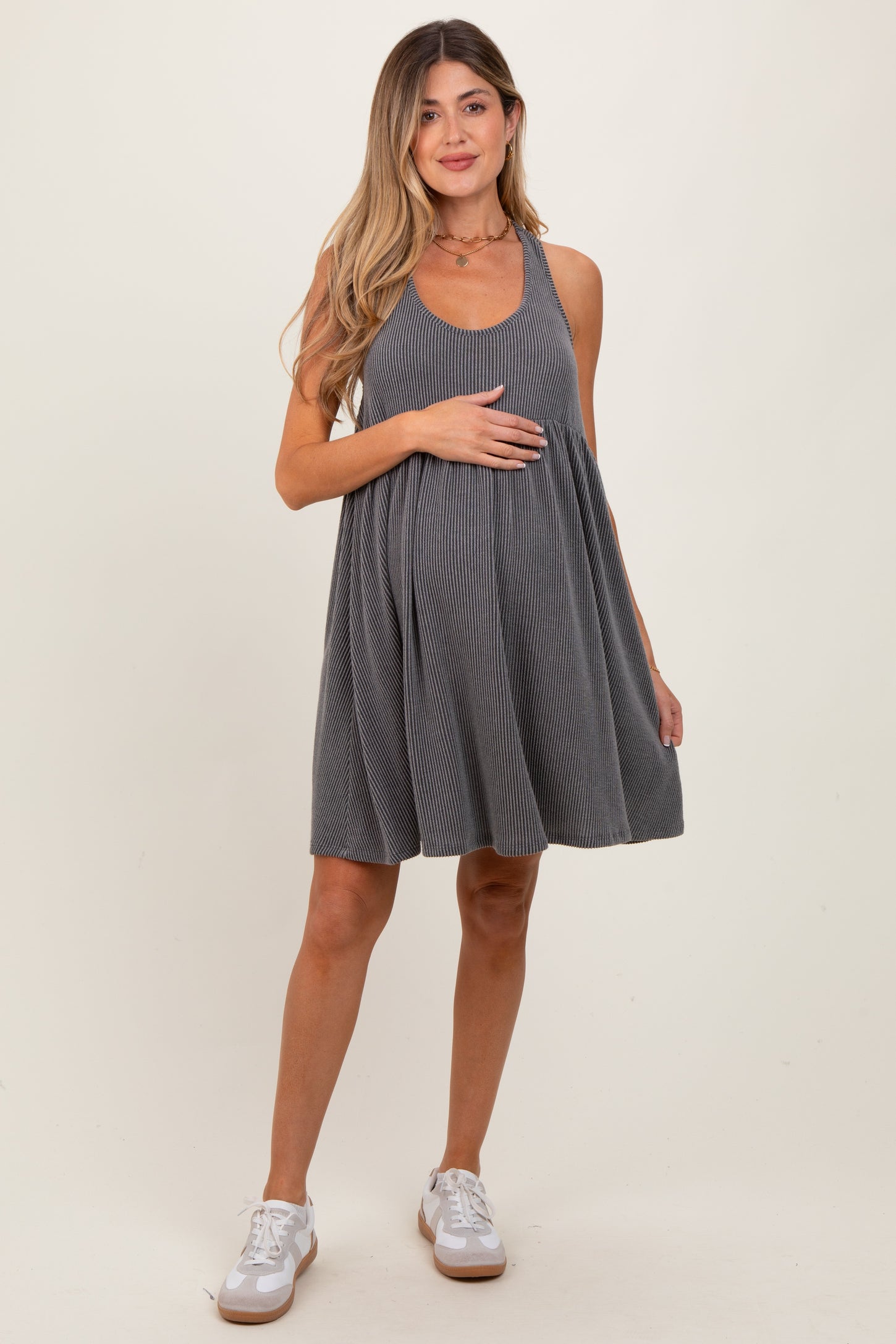 woman wearing a gray ribbed maternity dress and holding her baby bump
