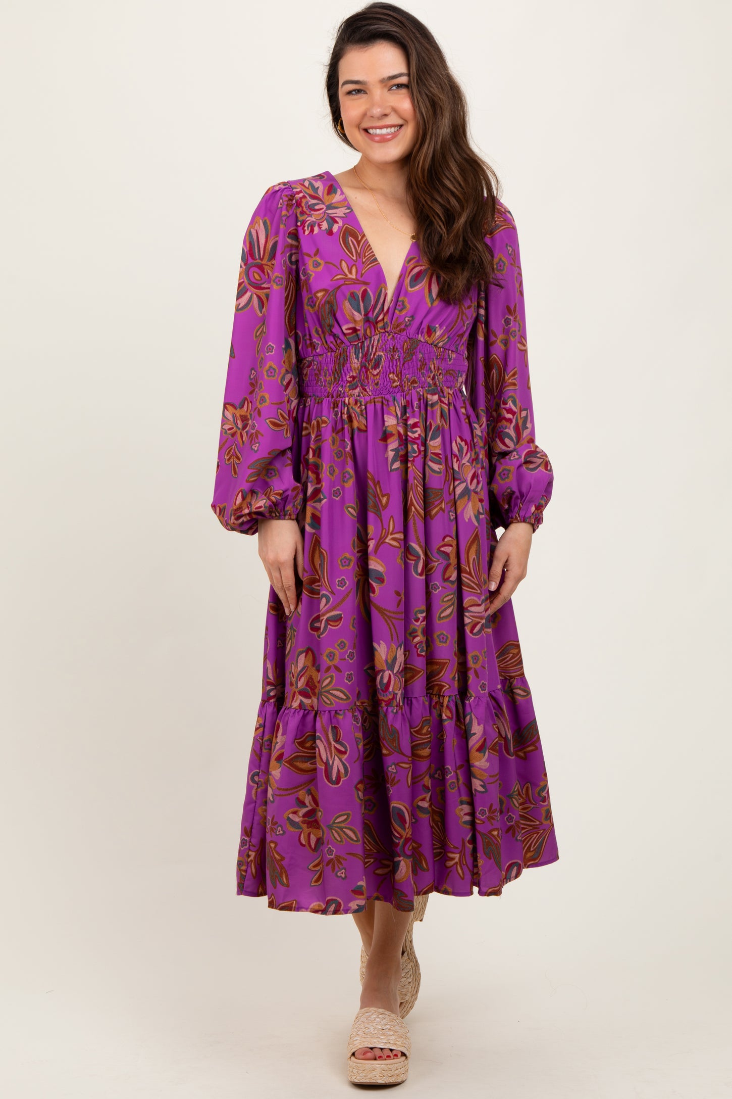 woman wearing a purple floral long sleeve maxi dress with a smocked waist and tiered skirt