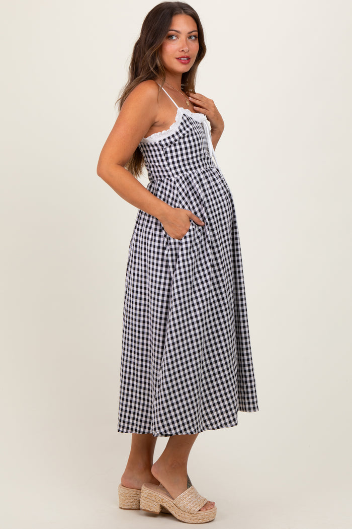 woman wearing a black and white gingham maternity dress with pockets and a visible baby bump