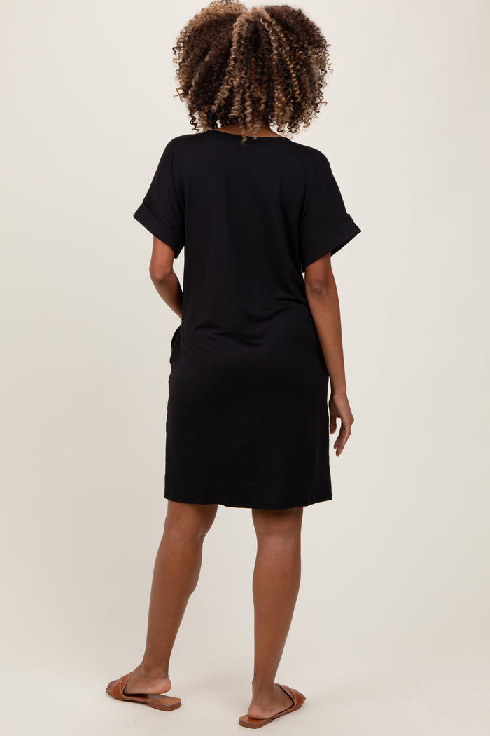 woman wearing a black short sleeve maternity dress, showing a relaxed fit from the back