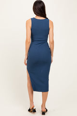 woman wearing a blue ribbed midi dress with a side slit and a fitted silhouette, shown from the back