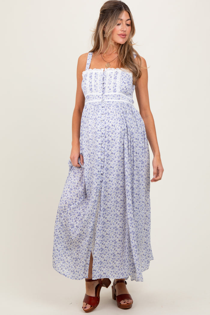 woman wearing a floral print maternity maxi dress with adjustable straps and a flowing skirt, showcasing her baby bump