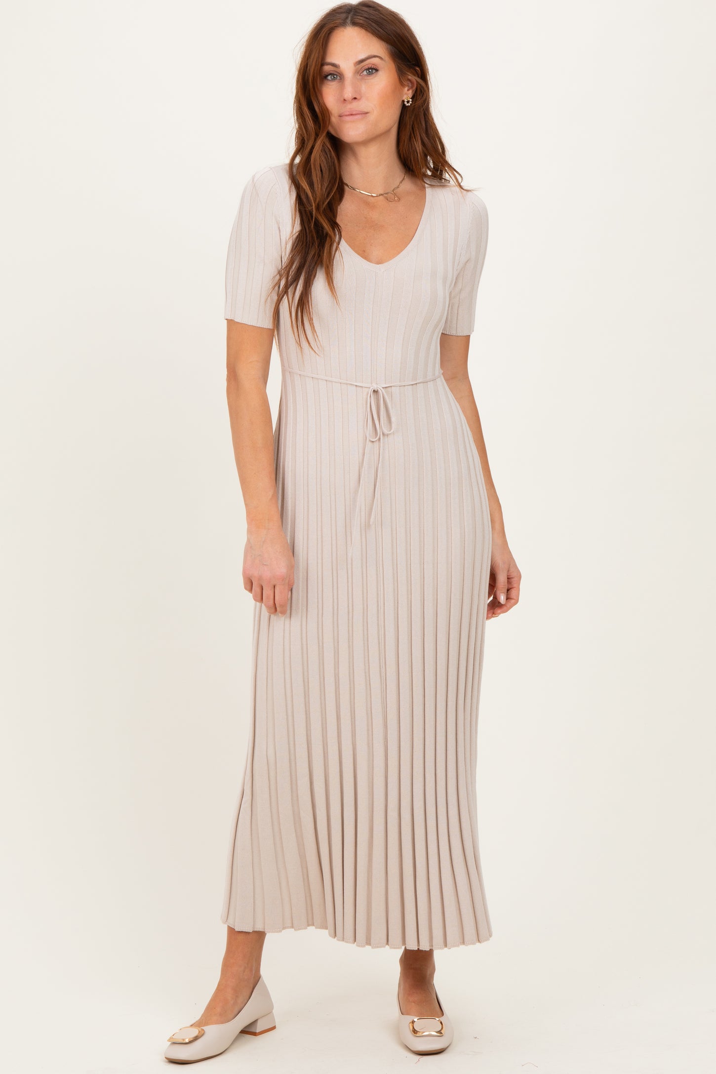 woman wearing a beige ribbed midi dress with short sleeves and a drawstring waist