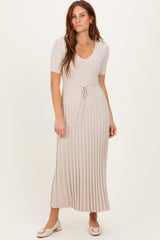 woman wearing a beige ribbed midi dress with short sleeves and a drawstring waist