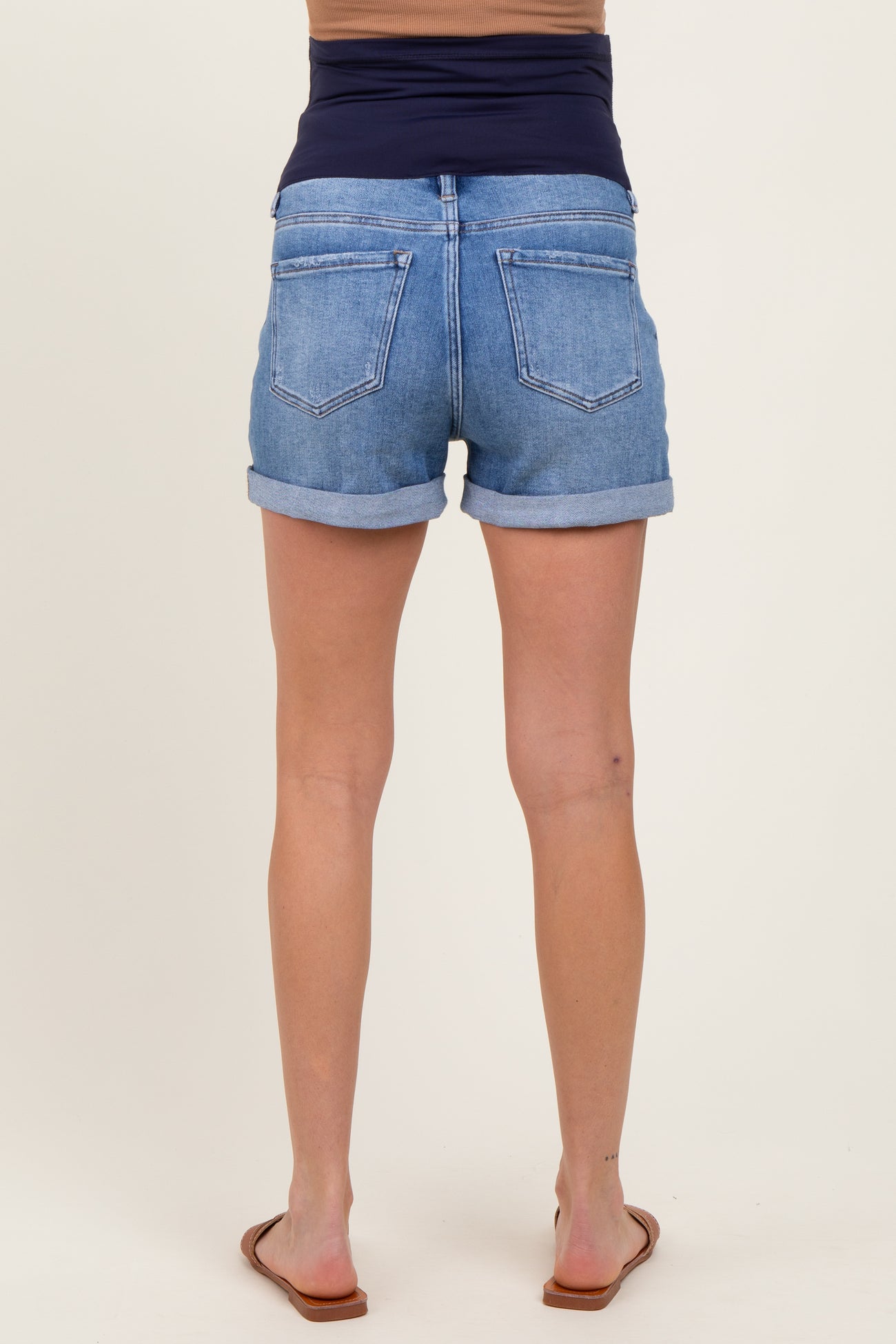woman wearing light blue maternity denim shorts, showing rolled cuffs and a comfortable waistband, back view