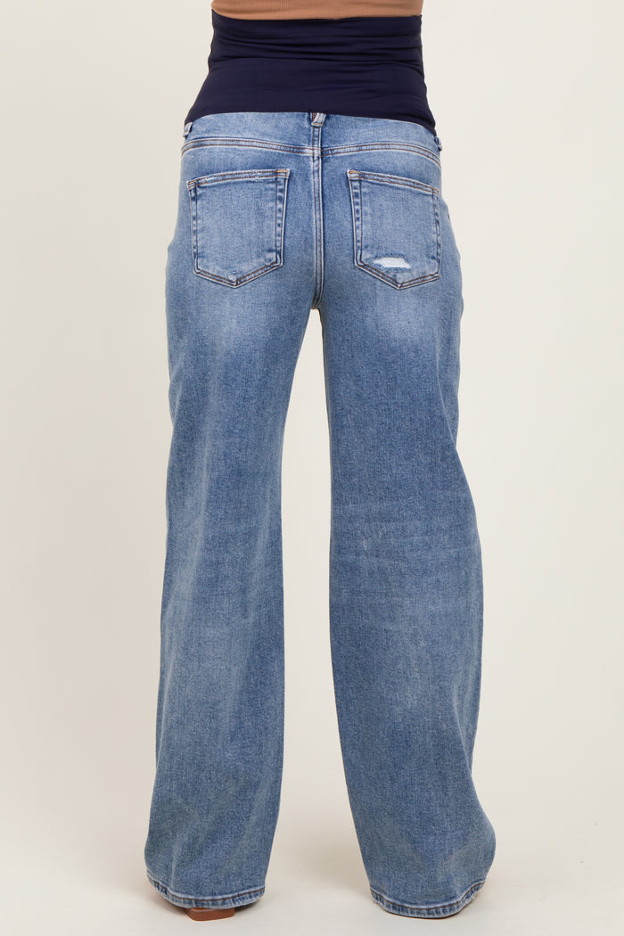woman wearing light blue maternity jeans with a relaxed fit and wide legs, showing the back view