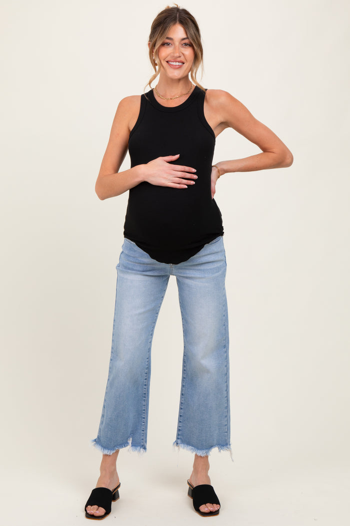 woman wearing a black ribbed maternity tank top and distressed light wash jeans, holding her baby bump