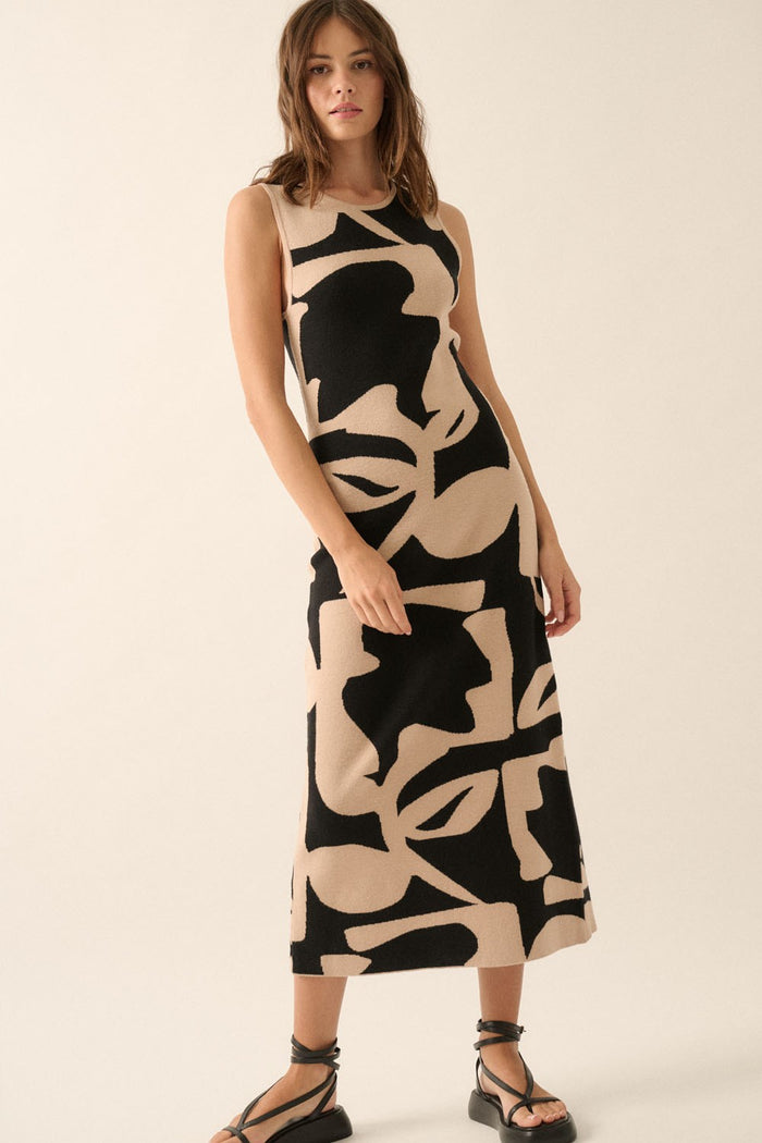 woman wearing a sleeveless black and beige patterned midi dress with a fitted silhouette