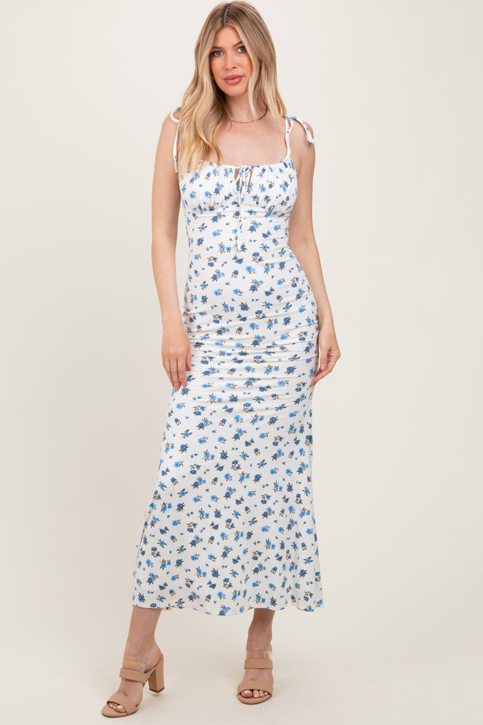 woman wearing a white floral maxi dress with tie straps and ruching details