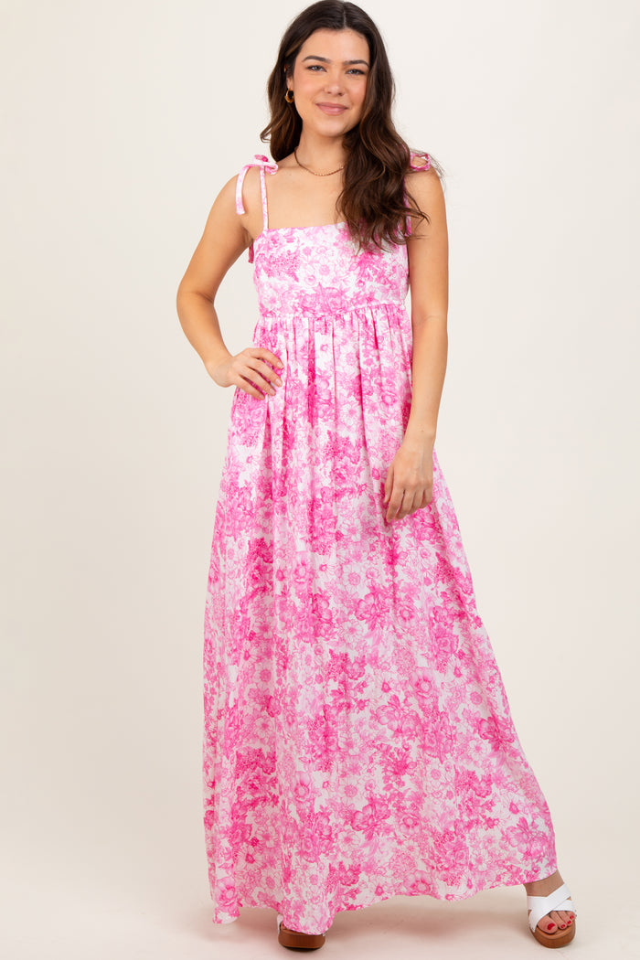 woman wearing a pink floral maxi dress with adjustable straps and a fitted bodice