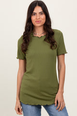 woman wearing a green ribbed short sleeve top with a scalloped neckline and styled with light blue jeans