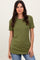 woman wearing a green ribbed short sleeve top with a scalloped neckline and styled with light blue jeans