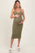 woman wearing a green ribbed maternity dress with buttons, holding her baby bump