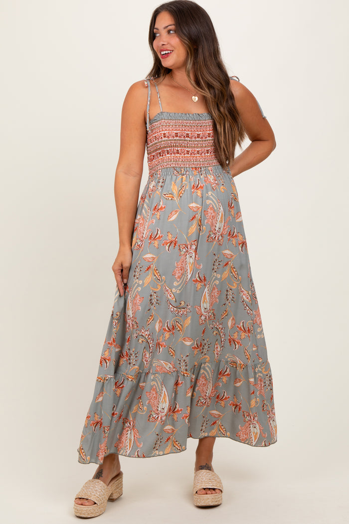 woman wearing a gray floral maxi maternity dress with smocked bodice and spaghetti straps