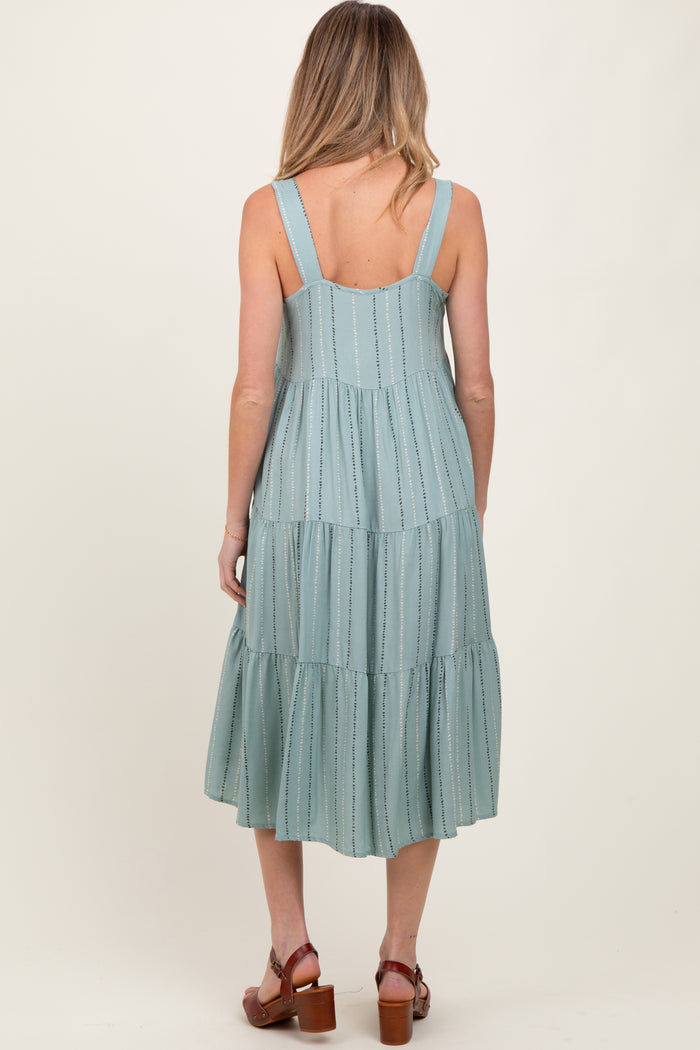 woman wearing a light green maternity sundress with tiered skirt and adjustable straps, showing the back view