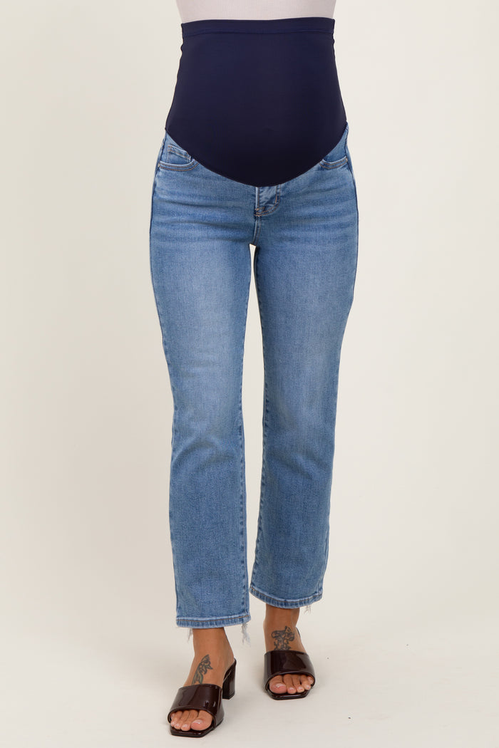 maternity wear in light wash blue jeans with a navy blue over-the-bump band, model wearing the jeans.