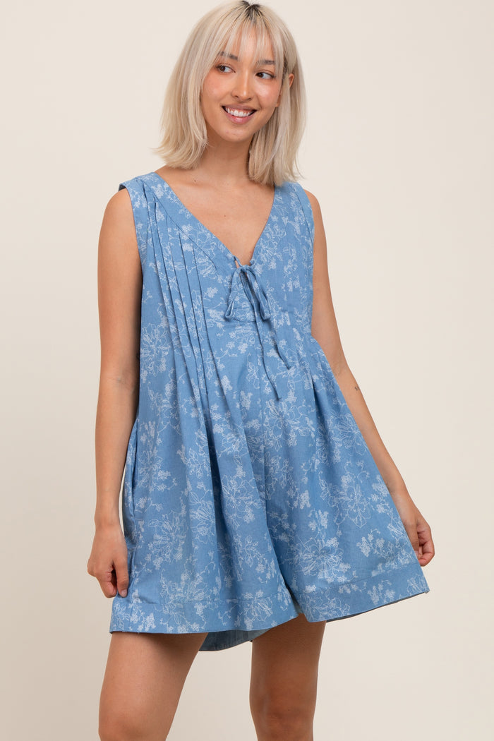 woman wearing a blue floral maternity dress with a v-neck and tie detail, showcasing her baby bump