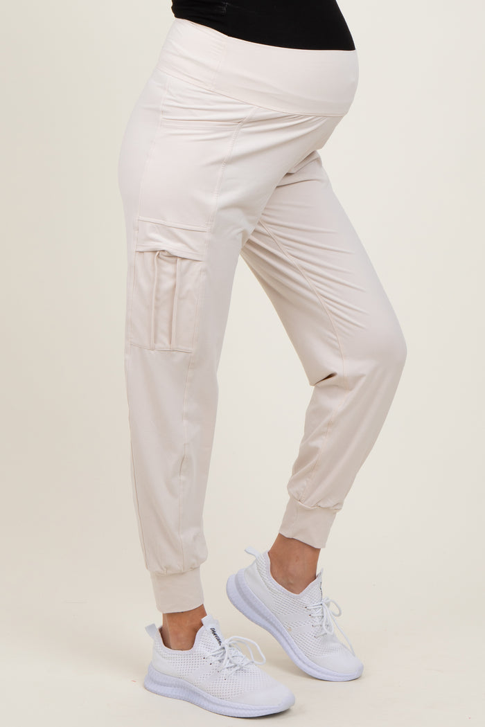 woman wearing light beige maternity joggers with pockets and a comfortable waistband