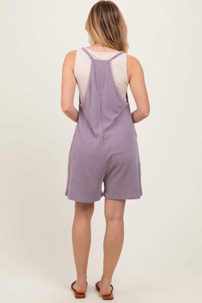 woman wearing a lavender striped romper with a racerback design and shorts length, viewed from the back