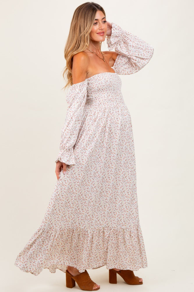 woman wearing a floral off-shoulder maternity maxi dress with bell sleeves and a visible baby bump