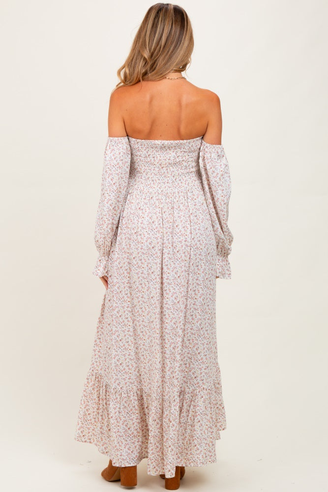 woman wearing a floral off-the-shoulder maternity maxi dress with long sleeves and ruffled hem