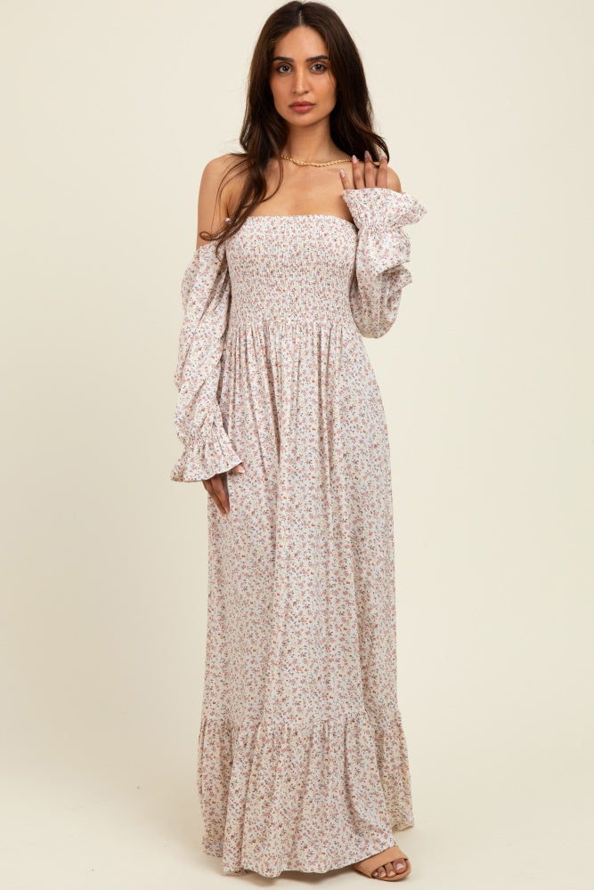 woman wearing a floral off-the-shoulder maxi dress with flared sleeves and a ruffled hem