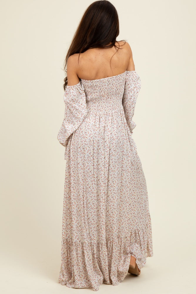 woman wearing a floral off-the-shoulder maxi dress with bell sleeves and a smocked bodice, showing the back view