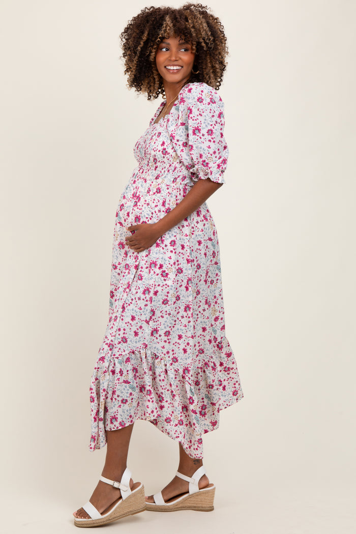 woman wearing a floral maternity dress with puff sleeves and a ruffled hem, showing her baby bump