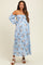 woman wearing a light blue off-shoulder maternity dress with floral print and tiered skirt, no visible baby bump
