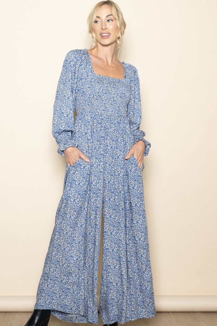 woman wearing a blue floral long sleeve maxi dress with a square neckline and pockets