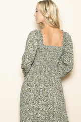 woman wearing a green floral maxi dress with puff sleeves and a square back neckline.