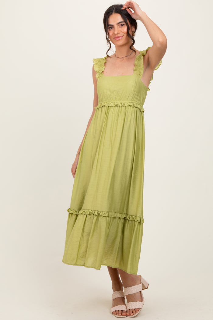 woman wearing a light green ruffled strap maxi dress with a tiered skirt and a fitted waist