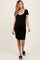 woman wearing a black maternity dress with a white trim and short sleeves, showcasing her baby bump